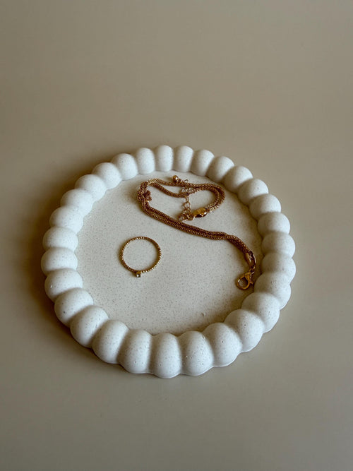 Bandeja redonda Bruma de Jesmonite con borde ondulado y acabado efecto mármol para organizar joyas y vaciabolsillos.